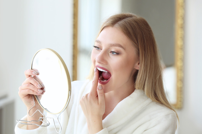 Patient checking their teeth in the mirror for cavities